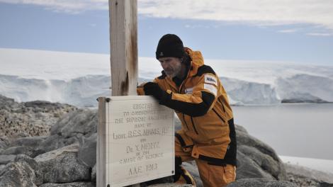 Ian Godfrey documenting the replica plaque attached to the Memorial Cross at Cape Denison